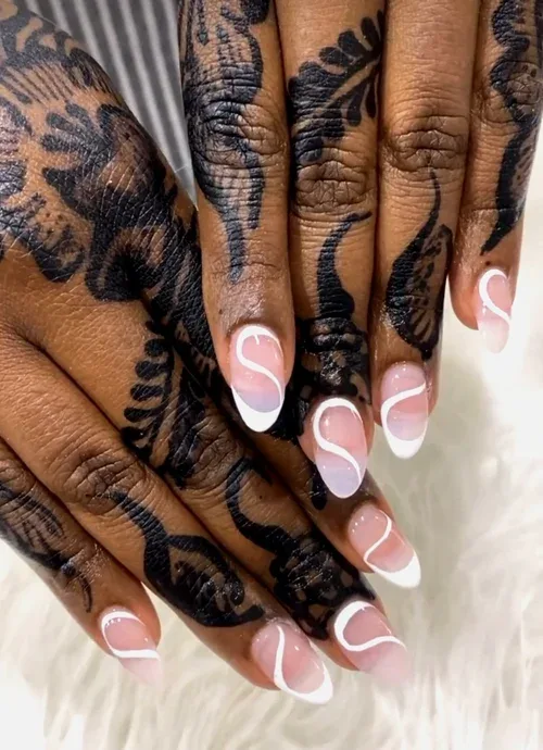 Henna Almond nail art — dark skin hands with black henna mehndi and white swirl French almond nails