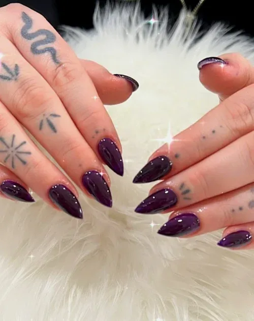 Dark Stiletto nail art — glossy dark aubergine stiletto nails with sparkle on white fur