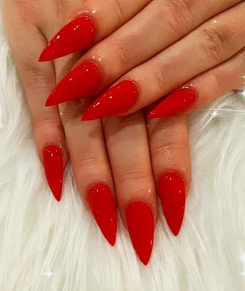 Scarlet Stiletto nail art — bright red glossy stiletto nails on white fur